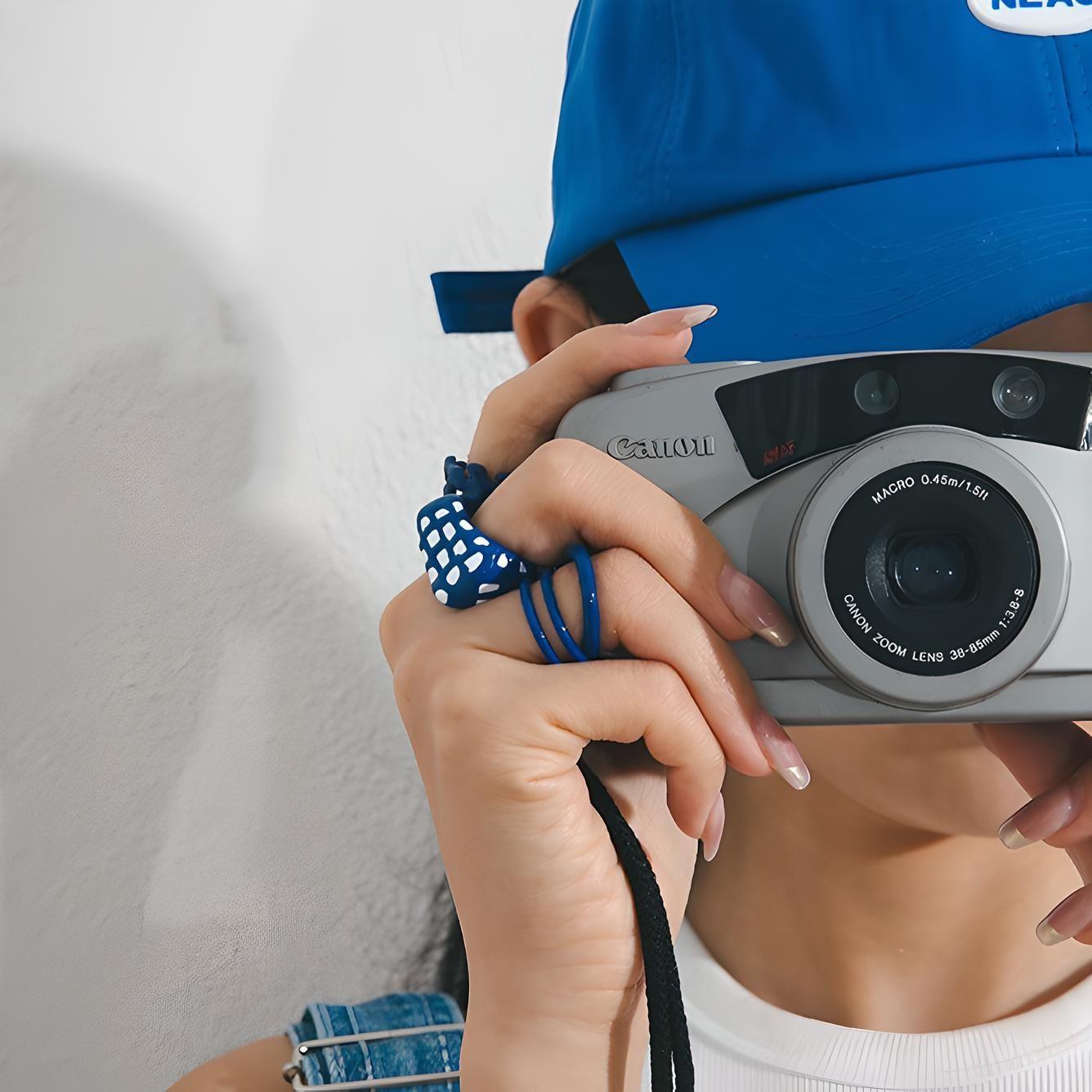 Fashion-forward photographer captures a moment in style, featuring a trendy blue cap paired with an on-point, vintage-inspired camera. Perfect for lifestyle and fashion blogs. #PhotographyFashion #VintageCamera #TrendyAccessories #LifestyleBlogging