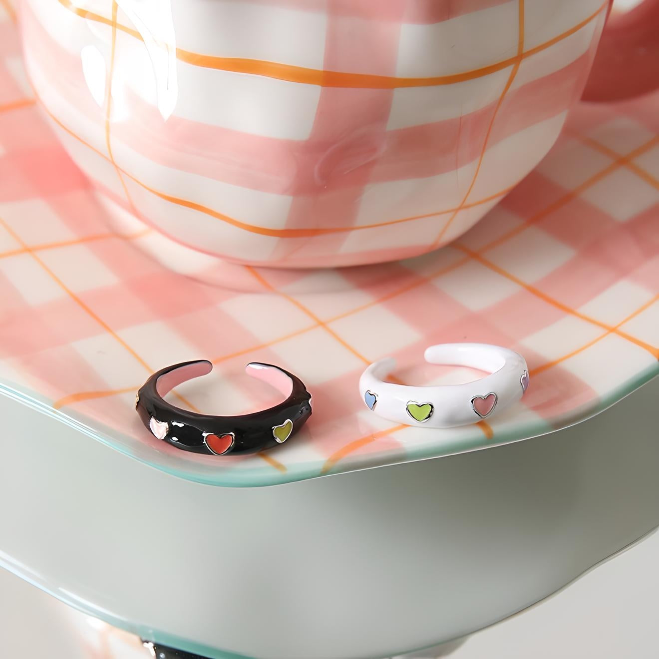 Elegant ceramic bracelets with heart accents on a pastel plaid tray, showcasing a trendy mix of accessory and home decor style. Perfect for a chic, modern aesthetic.